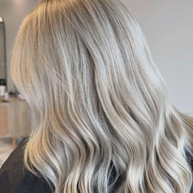 Icy ash-blonde, mid-length, finished in loose waves.