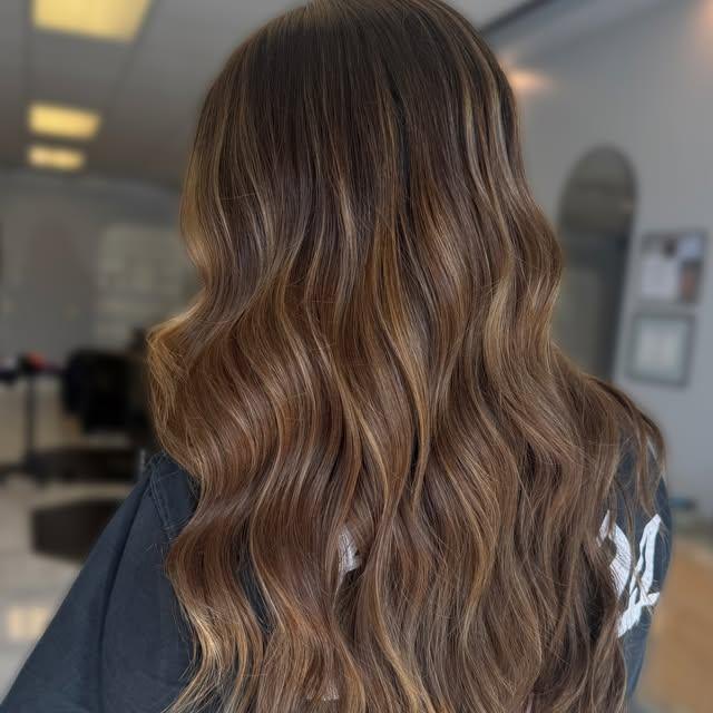 Warm brunette balayage with caramel through the mid-lengths and ends.